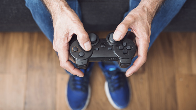 1568191406primer-plano-mano-hombre-mayor-que-sostiene-consola-videojuegos-23-2147935596